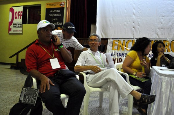 Several men and women sit in chairs at a table