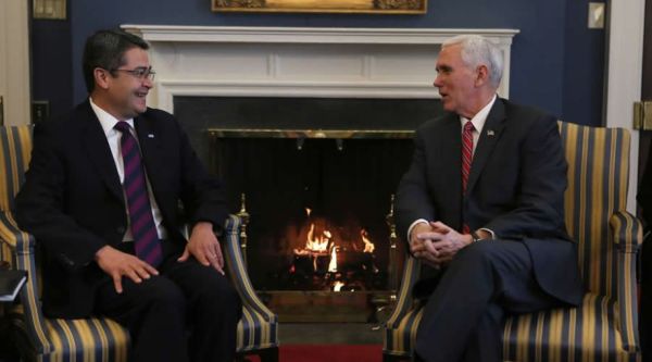 Two men sitting in chairs looking at each other.