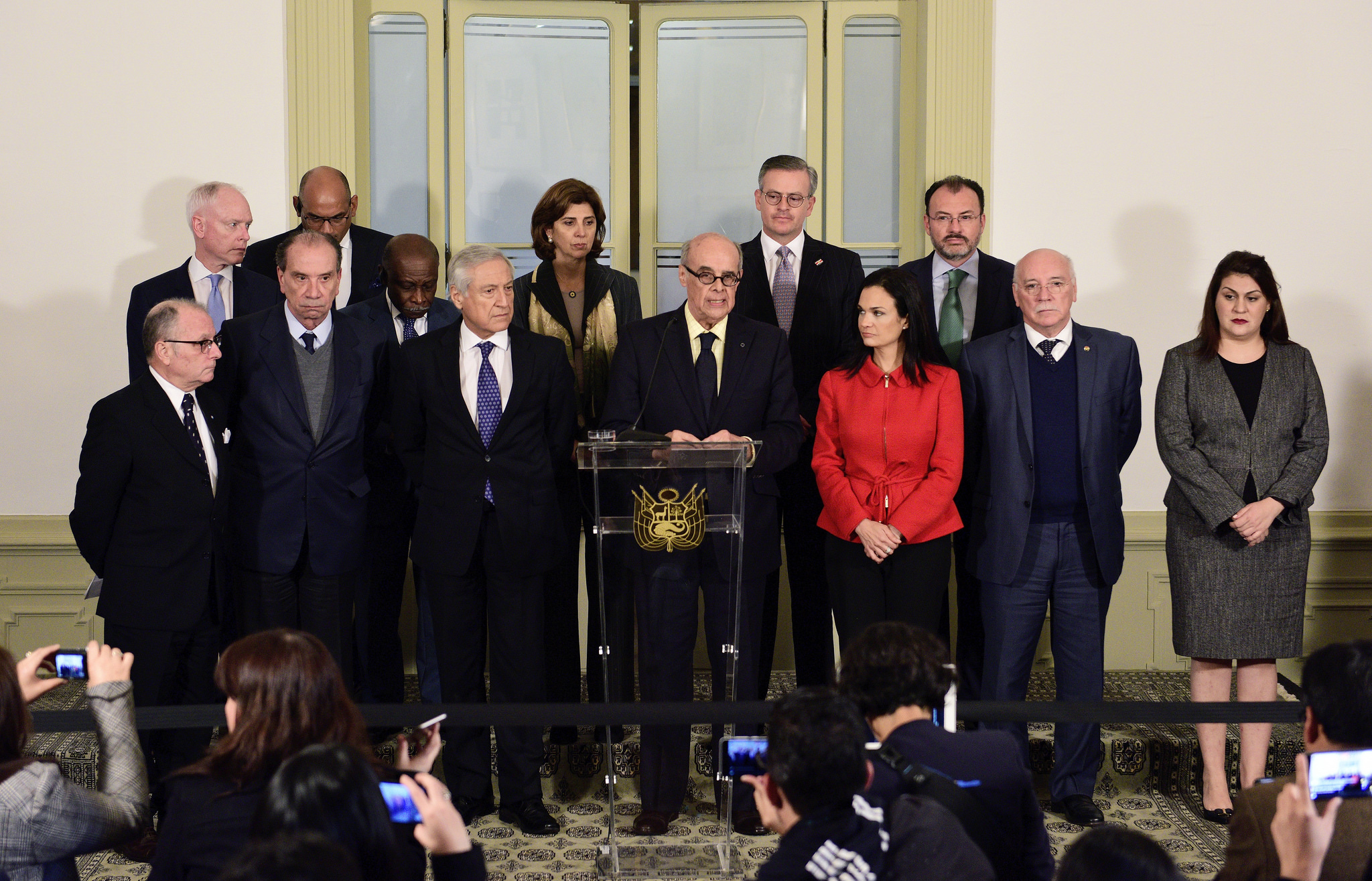 Group of men and women stand at a podium