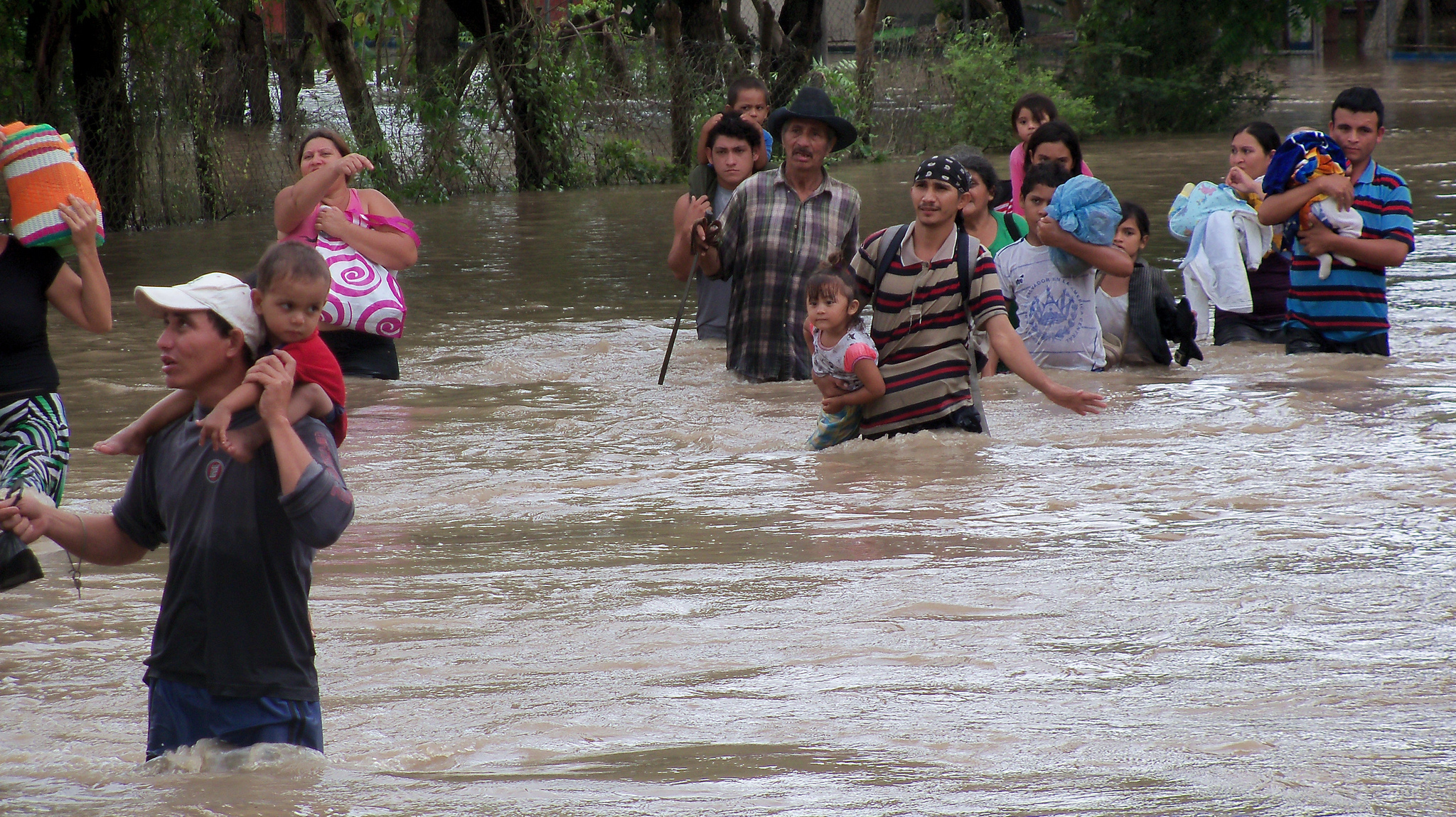 People wade through knee-deep water