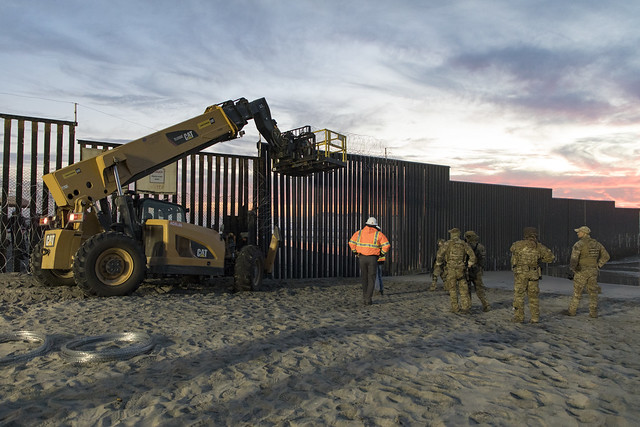 U.S. Border Patrol stands watch during border fence reinforcement / U.S. Customs and Border Protection / https://www.flickr.com/photos/cbpphotos/44997385775/in/photostream/