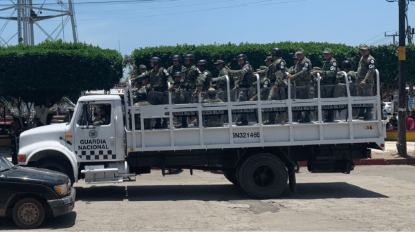 A truckload of military police, wearing National Guard armbands, passes through central Ciudad Hidalgo